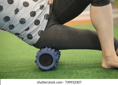 Woman Using A Foam Roll On Her Leg To Release Tension And Help With Muscle Pain In The Exercise Class