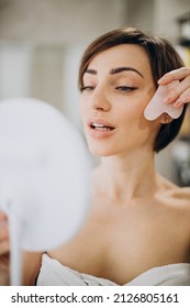 Woman Using Gua Sha Stone At Spa