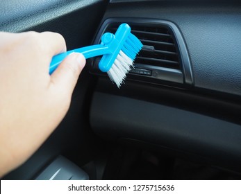 Woman Using Hand Hold A Car Cleaning Blue Brush For Airconditioner Cleaner On Grid Panel Console, Copy Space.