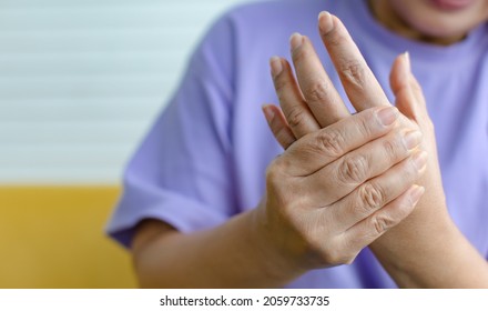 Woman Using Hand To Hold Other Her Palm With Feeling Pain, Hurt And Tingling. Concept Of Guillain Barre Syndrome And Numb Hands Disease.