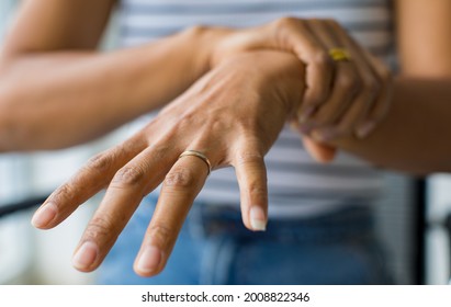 Woman In Using Hand To Hold Wrist And Stretching Fingers
 With Feeling Pain, Suffer, Hurt And Tingling. Concept Of Guillain Barre Syndrome And Numb Hands Disease.