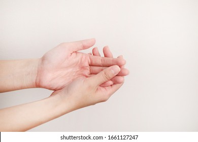 Woman using hand sanitiser on hands. The action of rubbing hand sanitiser on both hands. Importance of sanitising hands.