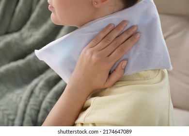 Woman Using Heating Pad At Home, Closeup