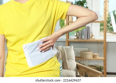 Woman Using Heating Pad At Home, Closeup