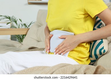 Woman Using Heating Pad At Home, Closeup