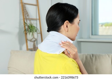 Woman Using Heating Pad On Neck At Home