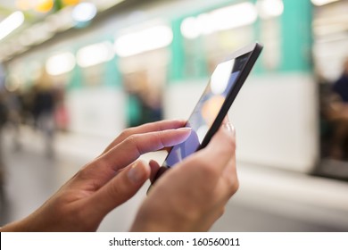 Woman using her cell phone on subway platform, message sms e-mail - Powered by Shutterstock