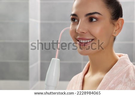 Woman using high frequency darsonval device in bathroom, closeup. Space for text
