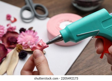 Woman Using Hot Glue Gun To Make Craft At Wooden Table, Closeup