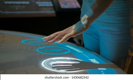 Woman using interactive display with no touch control technology at modern history museum. Education and modern concept