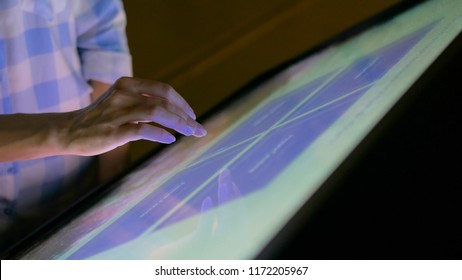 Woman Using Interactive Touchscreen Display At Modern Museum. Education And Technology Concept