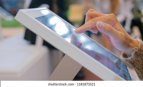 Woman using interactive touchscreen display at urban exhibition - scrolling and touching. Entertainment and technology concept - Shutterstock ID 1181873521
