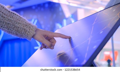 Woman Using Interactive Touchscreen Display With Unrecognizable Virtual Map At Modern Technology Show With Futuristic Interior