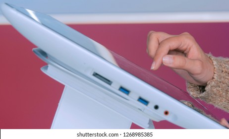 Woman using interactive touchscreen display at urban exhibition - scrolling and touching. Education and technology concept