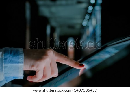 Woman using interactive touchscreen display of electronic multimedia kiosk at modern history museum. Education, learning and technology concept