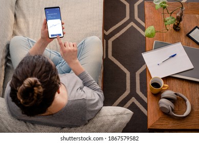 Woman using investment mobile app - Shutterstock ID 1867579582