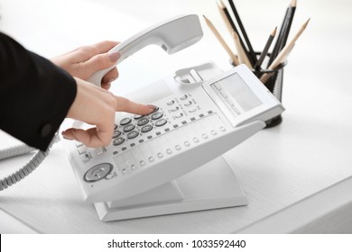 Woman Using Landline Phone In Office, Closeup