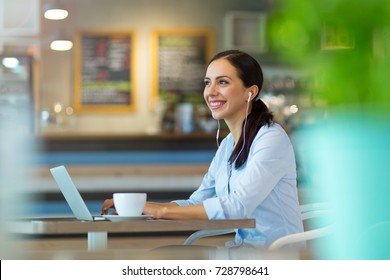 Woman Using Laptop In Cafe
