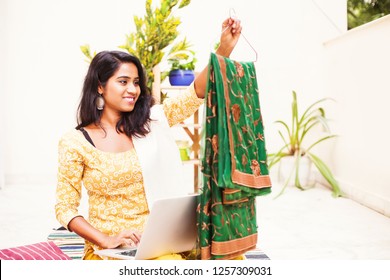 Woman Using Laptop And Checking The Saree That She Got Delivered From Online Store