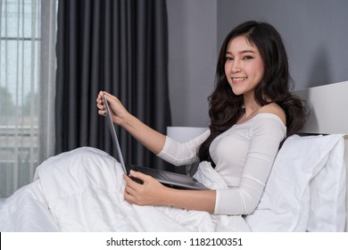 Woman Using A Laptop Computer On Bed