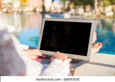 Woman Using Laptop Computer On Vacation In Luxury Resort