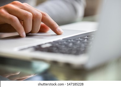 Woman using laptop indoor.close-up hand