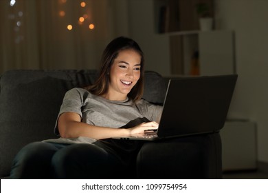 Woman Using A Laptop In The Night Sitting On A Couch In The Living Room At Home