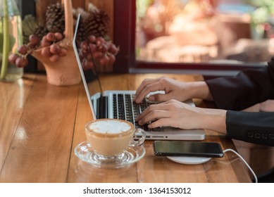 woman using laptop and smartphone in cafe