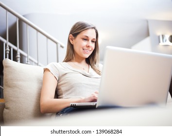 Woman Using A Laptop While Relaxing On The Couch