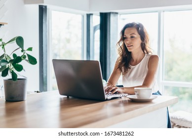 Frauen, die einen Laptop benutzen, während sie zu Hause sitzen