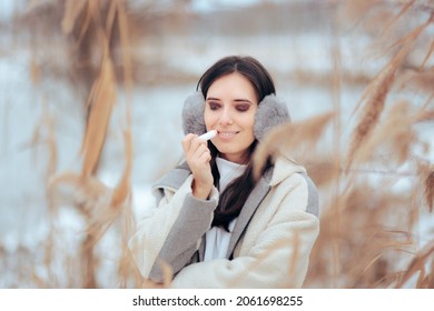 Woman Using Lip Balm in Winter Weather to Prevent Chapped Lips. Girl applying lipstick protection against dry skin
 - Shutterstock ID 2061698255