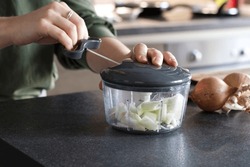 Woman Using A Manual Onion Chopper In The Kitchen