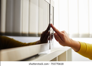 Woman Using A Microwave