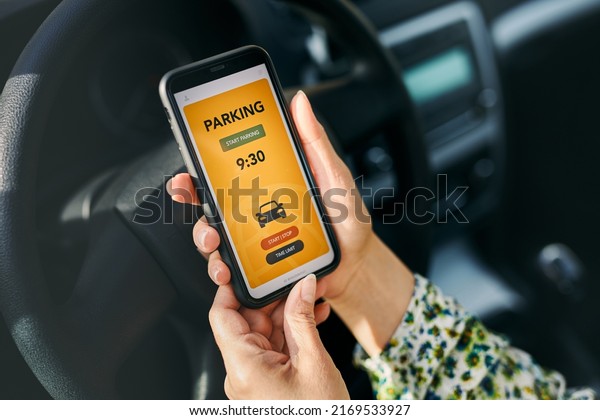 Woman using mobile parking app on smartphone. Driver\
using smartphone to pay for parking. Car park application on mobile\
phone. Convenience paying for parking using fast payment online.\
Car park