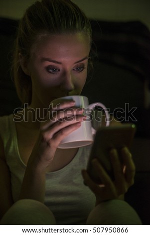 Woman using mobile phone. Female holding cup and coffee.