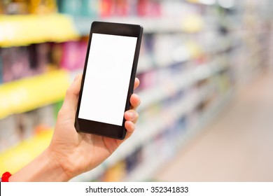 Woman Using Mobile Phone In Grocery Store 