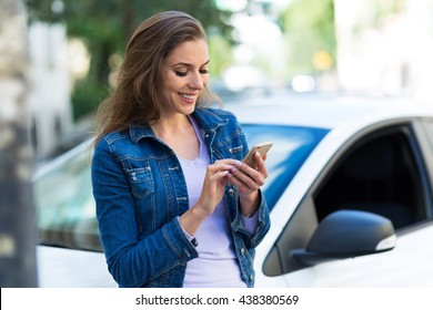 Woman Using Mobile Phone Near Car
