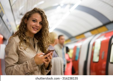 A Woman Using A Mobile Phone On The Tube Underground Station, London