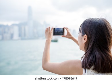 Woman using mobile phone to take photo - Powered by Shutterstock