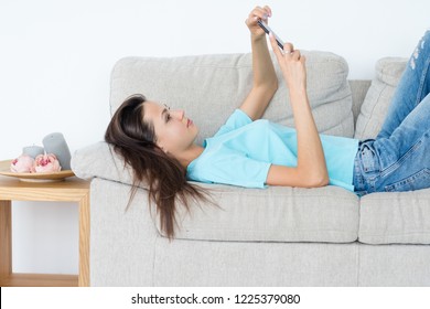 Woman Using Mobile Phone Updating Facebook Status. Leisure Habits. Communication And Social Network Addiction