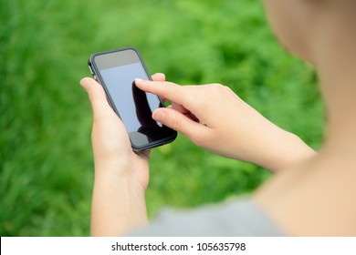 Woman Using Mobile Smart Phone In The Park.