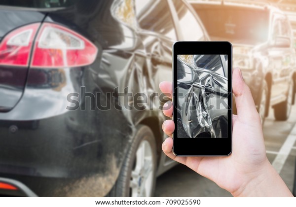 woman using mobile smart phone\
taking photo of the car crash damage accident for car\
insurance