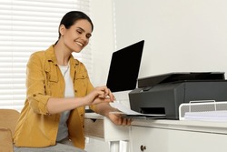 Woman Using Modern Printer At Workplace Indoors