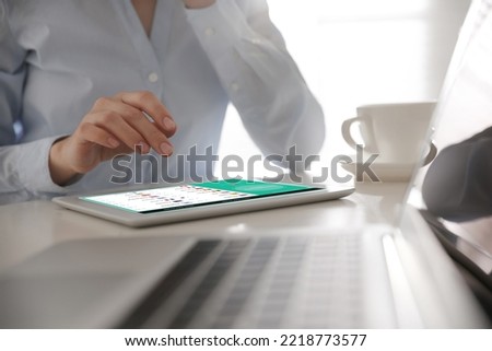 Woman using modern tablet with switched on VPN at table in office, closeup