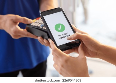 Woman Using  Mopbile Phone Payment to Transfer Money to Shop Seller - Powered by Shutterstock