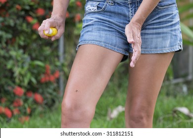 Woman Using Mosquito Repellent On Her Legs