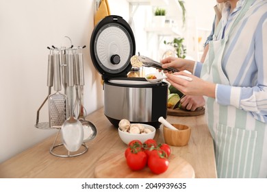 Woman Using Multi Cooker In Kitchen