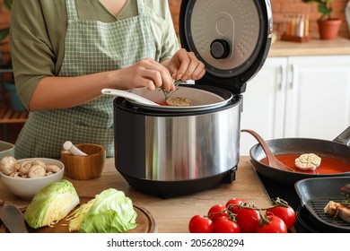 Woman Using Multi Cooker In Kitchen