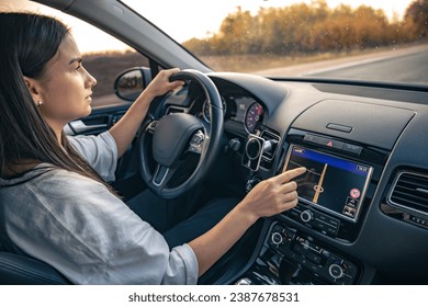 Woman using navigation system while driving a car.