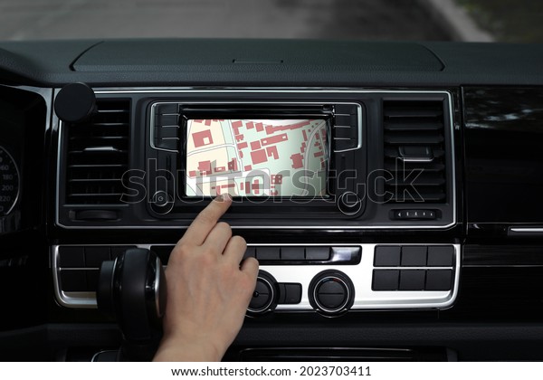 Woman\
using navigation system while driving car,\
closeup
